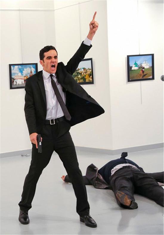 持枪男子打死俄罗斯驻土大使安德烈·卡尔洛夫后作出了一个愤怒的宗教手势。图片摄于土耳其安卡拉的一个美术馆，2016年12月19日。图片来源：Burhan Ozbilici/AP