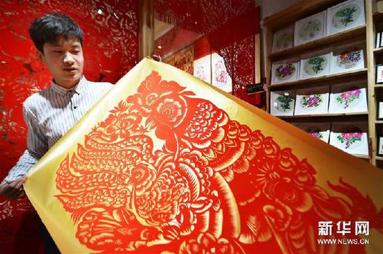 　　12月29日，畅杨杨正在创作剪纸作品《百鸡图》。