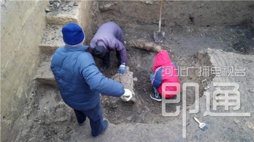 在一個探方里挖掘出一個磚結(jié)構(gòu)建筑，工作人員用小鏟和刷子一點一點把周圍的土清理掉。