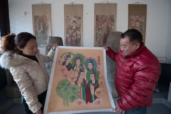 1月19日，姚淑龍（右）展示自己臨摹的毗盧寺壁畫局部。