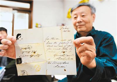 张太镒展示170多年前的信，上面有全世界发行的第一枚邮票——黑便士。 记者 翟小雪 摄