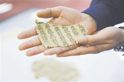 修复师向记者展示即将修复的一页西夏文古籍,据估测距今有500多年的历史。