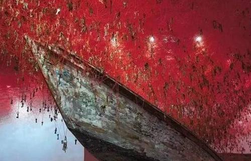 2015年威尼斯双年展上日本女艺术家盐田千春的装置作品《手中的钥匙》”（The Key In The Hand）。红色的线充满整个房间的天花板和墙壁，线上串着全球收集来的5万把钥匙。