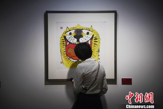 一位记者观看黄永玉的生肖画老虎。 杨华峰 摄 一位记者观看黄永玉的生肖画老虎。 杨华峰 摄
