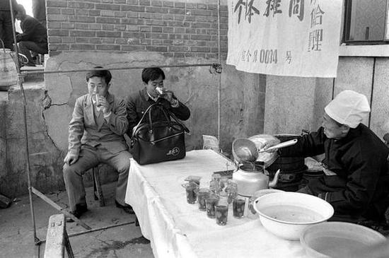前门地区，北京大碗茶摊位。北京，1986年。[摄影：Guy Le Querrec]