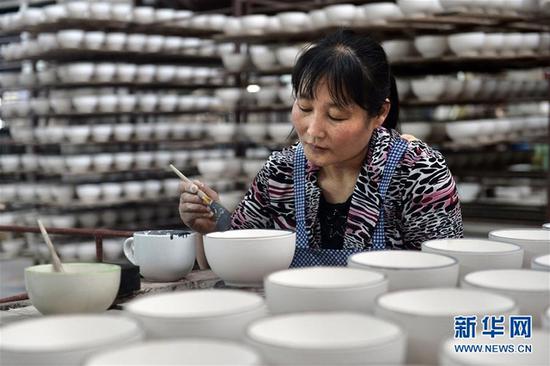 在淄博昆仑陶瓷有限公司生产车间，工人为陶瓷制品施釉（4月13日摄）。 新华社记者郭绪雷 摄