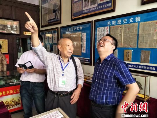邵阳薪火抗战历史文物博览馆馆长李连荣(中)在向市民介绍抗战历史文物。 张雪珊 摄