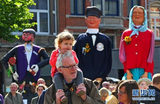 5月20日，在比利时鲁汶，人们观看展出的“巨人”。新华社记者龚兵 摄
