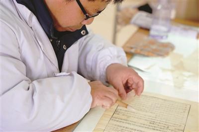 吴庭宏老师在修复古籍。
