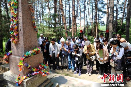 日本遗孤代表在“中国养父母公墓”墓碑前祭拜 王舒 摄