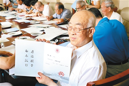 老教授文占申展示精心书写的录取通知书。图片来源于:西安晚报
