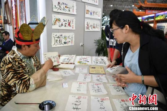 图为纳西族东巴现场书写东巴文。 刘冉阳 摄 图为纳西族东巴现场书写东巴文。 刘冉阳 摄