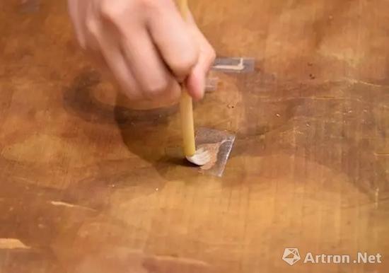 修复师将手工纸放在有撕裂处的背面，并糊上小麦淀粉