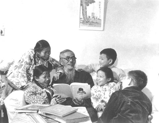 1962年，丰子恺与众孩在沪丰寓楼下看画册