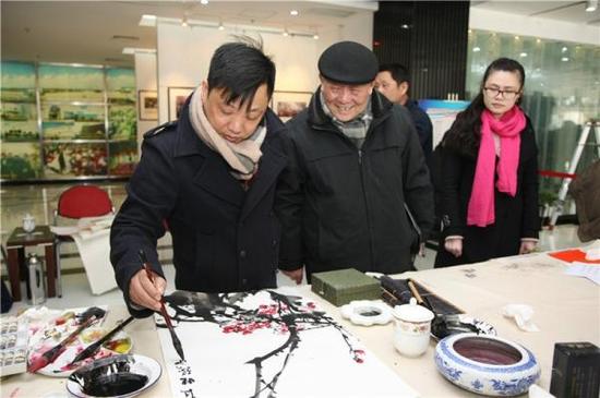 上海书画院浦东分院院长、浦东新区美术家协会主席徐立铨（左一）在村镇与书画爱好者交流
