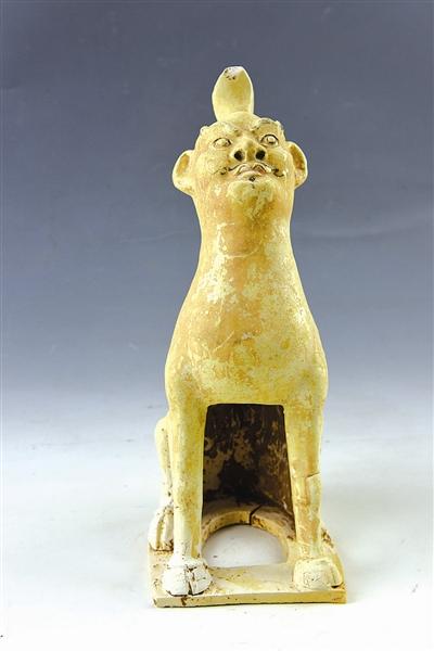 镇墓兽  高31.2cm。半蹲半立，独角，人面兽身。