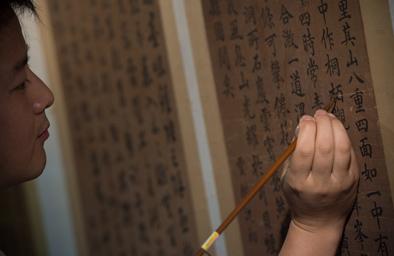 ▲安徽博物院文物科技保护中心书画修复师熊志杰在修补一张古人书法作品(10月13日摄)。