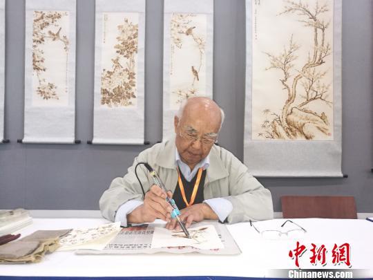 刘凯手持“火笔”作画 刘浩 摄