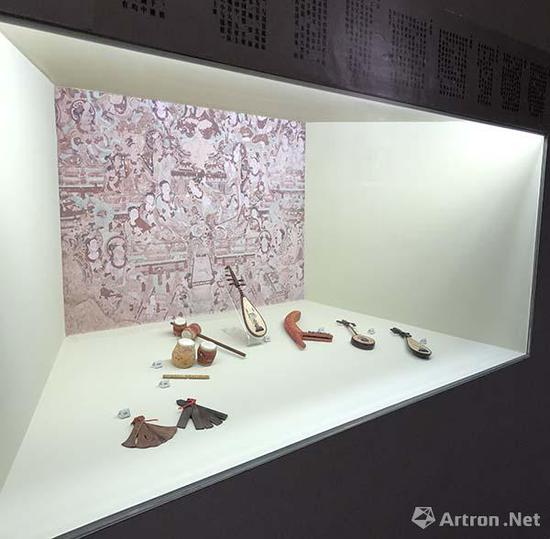展览现场复刻的敦煌乐器,并配以敦煌壁画场景并标注文字说明