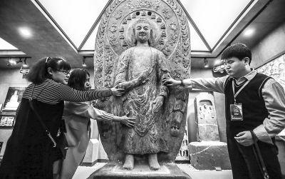 盲人在北京石刻艺术博物馆工作人员的引领下，用指尖感受石刻文化。记者 武亦彬摄