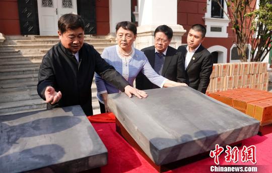 故宫博物院院长单霁翔(左一)向嘉宾介绍金砖并叩之听其响 杜洋 摄