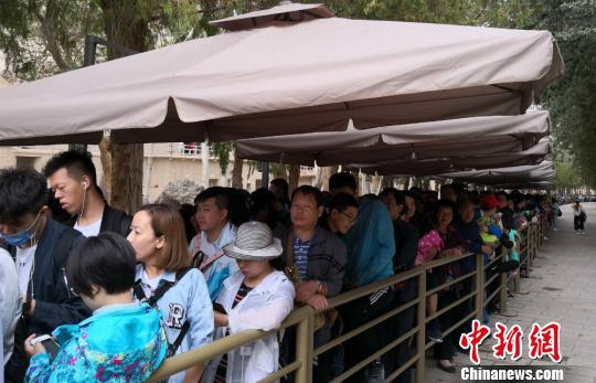 图为2018年8月中旬,莫高窟前等候参观的应急游客排成近1公里长队。(资料图) 冯志军 摄