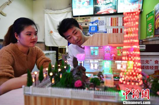 徐瑞斌和妻子一起欣赏自己的竹签工艺作品。 翟羽佳 摄