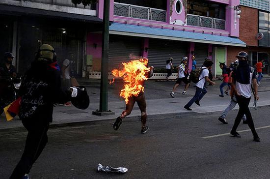 当地时间2017年5月20日，委内瑞拉加拉加斯，反总统抗议中，一名男子被火点着。