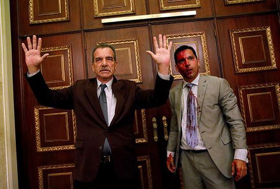 当地时间2017年7月5日，委内瑞拉加拉加斯，政府支持者在反对派控制的议会举行会议期间突然闯入，反对党议员Luis Stefanelli将双手举起。