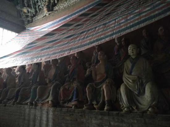 佛光寺东大殿殿内罗汉像顶部已盖上塑料布。 唐大华供图