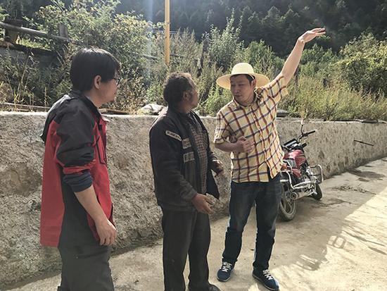 10月14日下午，刘杰文（右三）和牟建华（右一）向谷弄布村村民了解情况。