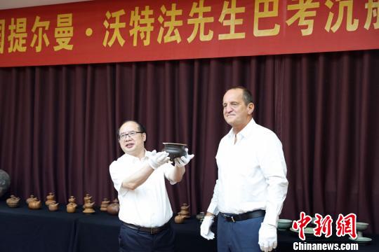 提尔曼-沃特法(右)向湖南省博物馆捐赠巴考沉船代表文物明景德镇窑酱釉三足香炉。湖南省博物馆供图