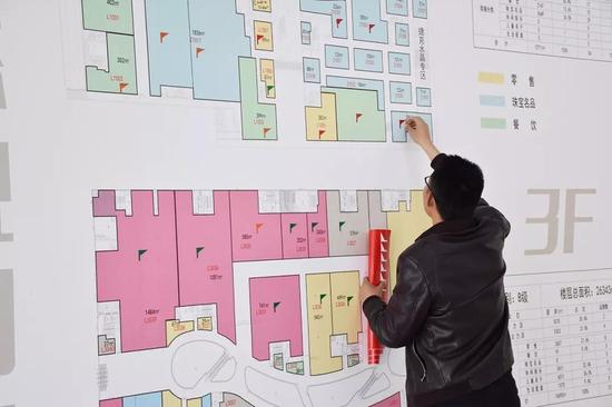 工作人员为选定商铺粘贴标识