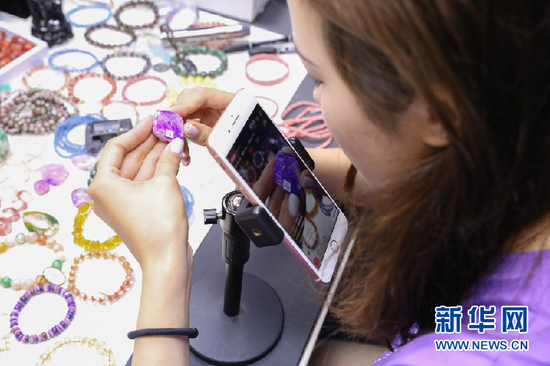 “芮芮”通过手机屏幕向网友展示水晶制品。