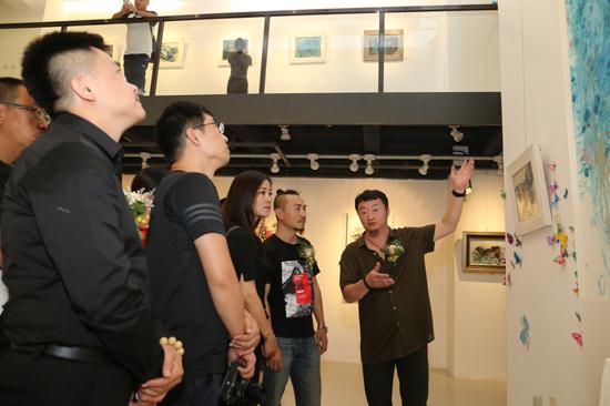 本次展览的画家乙卜先生在给嘉宾介绍作品之敦煌蝶舞