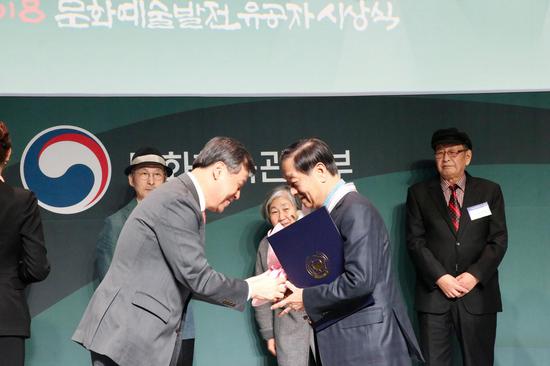 韩国文化体育观光部长官都钟焕宣读由韩国总统文在寅签署的《文化勋章证书》,并为韩美林佩戴“韩国文化勋章”奖章