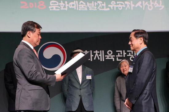 韩国文化体育观光部长官都钟焕宣读由韩国总统文在寅签署的《文化勋章证书》,并为韩美林佩戴“韩国文化勋章”奖章2