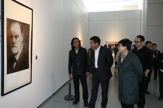 苏新平、贺淑荣、徐志强在画展现场观看作品。