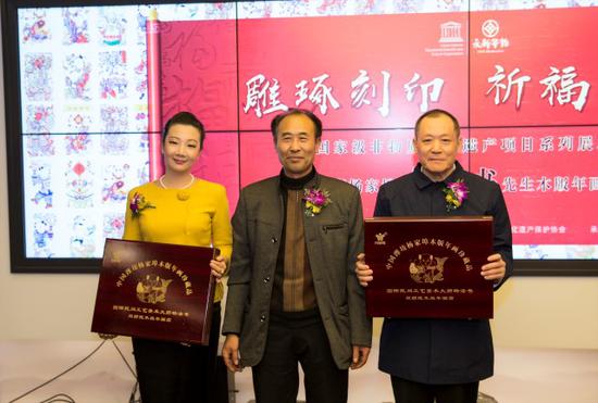 中国非遗保护协会会长马文辉(右)、永新华韵文化产业有限公司总裁张坤兰(左)代表协会与公司接受杨付江先生(中)赠礼