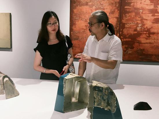 “海派漆艺中的城市色彩——翁纪军漆艺作品展”展览现场:翁纪军向嘉宾马琳介绍《山水系列》