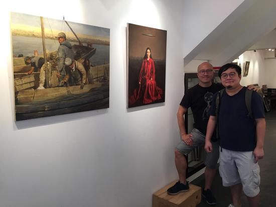 前加拿大安大略省美术学院（ocad）绘画系教授Harvey Chan（左）与香港学生前来参观邸可新画展。