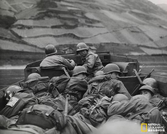 1945年3月26日，美国第三军第八十九师的士兵蜷缩在水陆两用车中，穿过德国上韦瑟尔（Oberwesel）附近的莱茵河段。供图：美国国防部