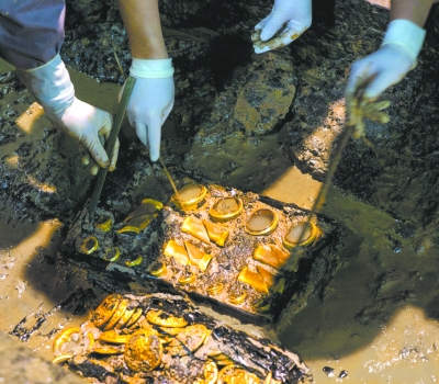 11月17日，考古人员在墓主椁室西侧发现1盒马蹄金和2盒金饼，总数超过75枚。郭 晶  摄