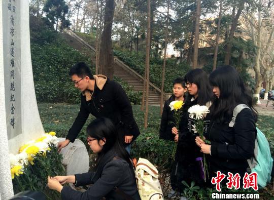 河海大学的学生们还自发的携菊花,来到清凉山南京大屠杀遇难同胞纪念碑前,悼念逝去的同胞们 盛捷 摄