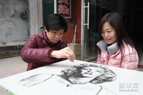 12月9日，河南省灵宝市的理发师李海良在用碎头发进行“发画”创作。