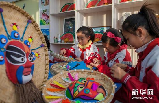 12月17日，内蒙古呼和浩特市玉泉区通顺街小学的学生在制作面具作品。