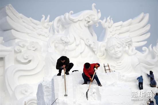 12月22日,在太阳岛雪博会园区,选手在进行雪雕作品创作。