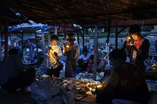 曼德勒,缅甸商人在市场上检查玉器。资料图片