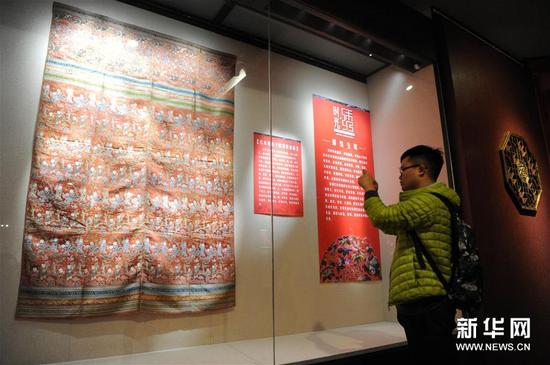 12月31日,市民在一件“蜀锦被面”刺绣展品前拍照。