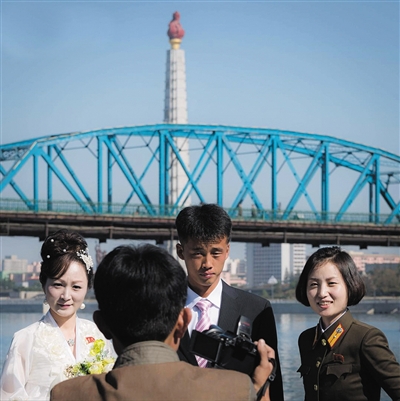 平壤,市民在江边拍婚纱照。
